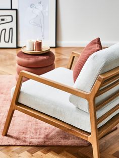 a white chair sitting on top of a hard wood floor next to a pink rug