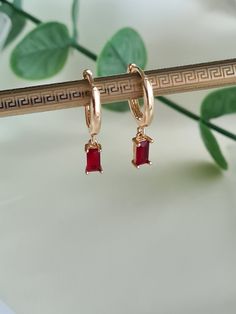 ❤Gorgeous little pair of Gold huggies handmade with a small red zircon  charm. ❤These long lasting 18K Gold plated huggies are 15mm in diameter and the red zircon rectangular charm just 8mm x 4mm.  ❤Hypoallergenic and great for sensitive ears. ❤Perfect earrings for everyday wear or that special occasion and will come with a lovely velvet pouch ready for gifting 🎁  Due to individual monitors colours may vary but please contact me with any queries. Thanks for checking out my etsy shop 🙂 Dainty Red Earrings For Everyday, Dangle Huggie Earrings With Charms For Gifts, Red Huggie Earrings Gift, Red Huggie Earrings For Gift, Hypoallergenic Red Hoop Earrings For Everyday, Everyday Hypoallergenic Red Hoop Earrings, Elegant Huggie Earrings With Charms For Gift, Elegant Huggie Earrings With Charms As Gifts, Gold Plated Huggie Earrings With Charms As Gift