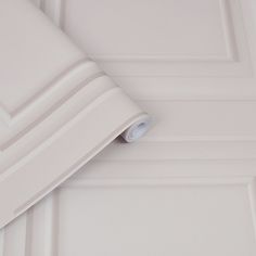 a close up of a white wall with a roll of paper on it's side