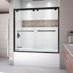 a bathroom with a glass shower door and white tile walls, along with a sink