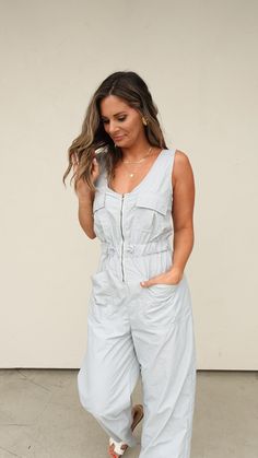 Blue/gray nylon jumpsuit Zipper front (nursing friendly) Cargo-inspired pockets at chest Front pockets Wide leg Elastic waistband with adjustable drawstring Open criss-cross back Runs true to size with a relaxed fit. Elizabeth and Lauren both shown in the size small Utility Style Sleeveless Jumpsuits And Rompers With Pockets, Gray Jumpsuits And Rompers With Pockets For Spring, Gray Spring Jumpsuits And Rompers With Pockets, Casual Gray Jumpsuits And Rompers For Work, Gray Jumpsuit, Grey Jumpsuit, Nursing Friendly, Resort Wear, Blue Gray