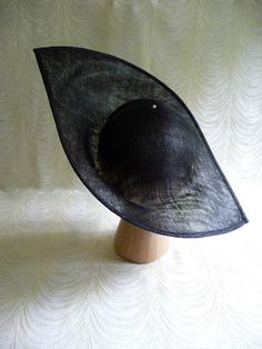 "One large sinamay straw hat base in black in an oblong shape that measures approximately 13\" (33.00 cm) at its widest point and approximately 17\" (43.18 cm) at its longest point. Deep curvature to fit against your head. The stiffened sinamay straw is feather light but has a great sturdy weave that provides excellent support for your millinery creations. Edge finished with sinamay. Shipped in an oversized box, hence the higher than normal postage charge. May have to ship separately for some in Sinamay Church Hat With Curved Brim, Black Short Brim Boater Hat For Church, Formal Black Boater Hat With Curved Brim, Black Wide Brim Hat For Royal Ascot, Black Mini Hats For Summer Church Events, Black Wide Brim Boater Hat For Church, Black Mini Hats For Church In Summer, Black Mini Hat For Church In Summer, Black Summer Church Hat