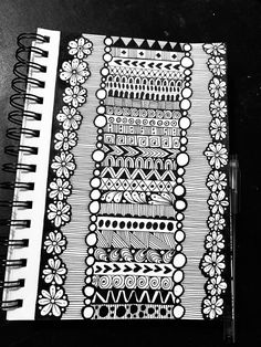 a black and white photo of a notebook with an intricate design on the front cover