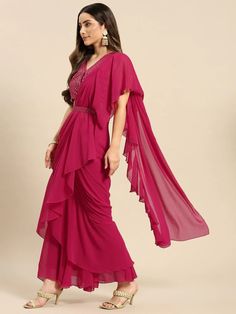 Step out in style with this set from VitansEthnics. Don this look this season for a festive outing with family and friends. Pair it with heels and a clutch to complete the look. Add chunky jewelry like jhumkas and choker accessories. The clothing set consists of one shoulder crop top with a skirt and an attached dupatta. Sizes: To Fit Bust(in inches): S(33), M(35), L(37), XL(39), 2XL(41) To Fit Waist(in inches): S(29), M(31), L(33), XL(35), 2XL(37) Fabric: Georgette Style: Crop Top With Skirt an Bollywood Style Ruffled Dresses For Navratri, Festive Anarkali Set With Ruffles, Festive Pre-draped Maxi Length Georgette Saree, Fitted Dress With Cape Sleeves For Navratri, Ruffled Anarkali Set For Diwali, Designer Ruffled Dresses For Eid, Bollywood Festive Dresses With Ruffles, Festive Bollywood Dresses With Ruffles, Georgette Dress With Cape Sleeves For Eid