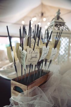 there are many place cards on sticks in the holder for guests to write their names