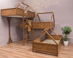 a teddy bear sitting on top of a wooden bunk bed next to a potted plant