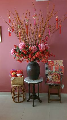 a vase filled with flowers sitting on top of a table next to a small stool