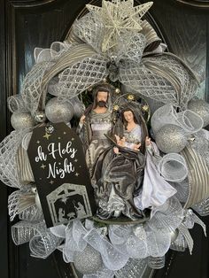 a christmas wreath with a nativity scene in the middle and an ornament on top