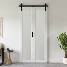 a room with white walls and two doors that have black hardware on the handles,