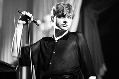 black and white photograph of a woman singing on stage with a microphone in front of her