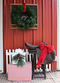 a horse with a red ribbon tied around it's neck sitting next to a christmas present