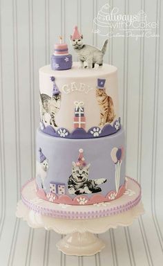 a three tiered cake with cats on it