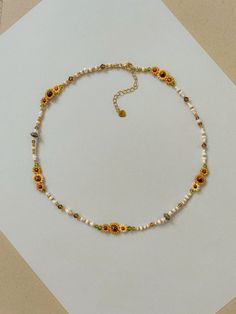 This necklace features different shades of hand woven yellow sunflowers and fall colors of cream, brown, green, and gold. 

Length: 16.5- 19inches

Seed Bead Size: 11/0, 6/0

This dainty piece is made up of high quality seed beads including 24kt gold plated beads, crystals, and tigers eye.

Adjustable: Each necklace has a 2.5” gold filled lobster clasp extender


Strung on: Non-Stretchy Beading Thread
#flowerstagram #sunflower #whimsical #goldjewelryideas #falloutfitideas #autumn #fallfashiontrends #cottagecore Sunflower Beaded Necklace, Dainty Diy Jewelry, Autumn Necklace Fall Jewelry, Aesthetic Bead Necklace, Fall Beaded Jewelry, Sunflower Beaded Bracelet, Seed Bead Necklace Ideas, Seed Bead Flower Necklace, Bead Necklace Ideas