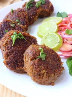 some meat patties are on a plate next to sliced radishes and cucumbers