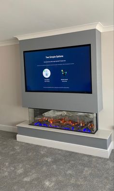 a large flat screen tv mounted on top of a wall next to a fire place