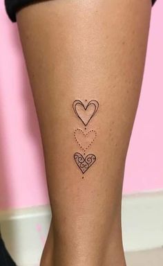 a woman's leg with two hearts tattoo on the back of her left leg