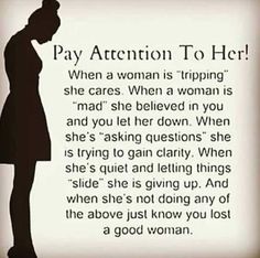 a woman standing in front of a sign that says, pay attention to her when a woman