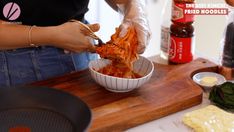 a woman is preparing food in a bowl on a cutting board with other ingredients around her