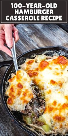 a skillet filled with cheese covered casserole on top of a wooden table