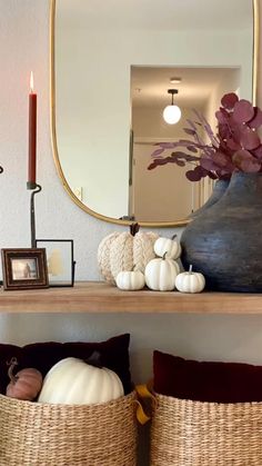 a shelf with baskets and candles on it