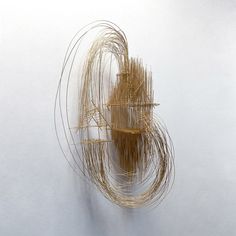 a sculpture made out of sticks on a white wall