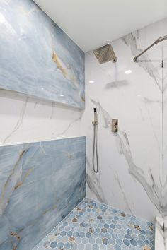 a bathroom with blue and white tiles on the walls, shower head, and hand held shower faucet