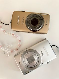 a camera and necklace laying next to each other on a white surface with beads around it