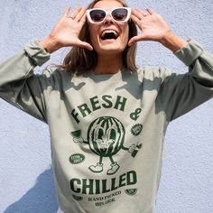 Extra juicy summer sweater.  Printed sweatshirt by Batch1 Slogan to front: "Fresh and Chilled" Graphics: Vintage style watermelon character  Print: Organic, water-based, eco-friendly ink Style: Crew neck, long sleeves Fit: Relaxed, Unisex Size Guide: XS - 8 | S - 10 | M - 12 | L - 14 | XL - 16 | XXL - 18/20 Model wears size Large  Material: 80% cotton, 20% polyester, brushed fleece inside   Sustainability: Ethically made to order in the UK  | WRAP Certified  | Sedex Sourced | Vegan  Care: Machin Green Relaxed Fit Sweatshirt For Summer, Trendy Summer Sweatshirt With Letter Print, Trendy Summer Sweatshirt With Screen Print, Casual Cotton Sweatshirt With Funny Print, Summer Cotton Sweatshirt With Screen Print, Summer Crew Neck Sweatshirt With Graphic Print, Oversized Summer Sweatshirt With Graphic Print, Oversized Graphic Print Sweatshirt For Summer, Trendy Summer Leisure Sweatshirt