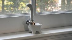 a toothbrush holder sitting on the window sill