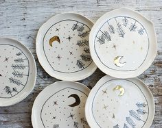 four plates with designs on them sitting on a table