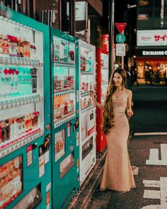 a woman standing next to a vending machine