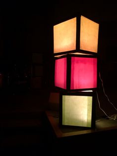 a lamp that is lit up in the dark with some lights on top of it