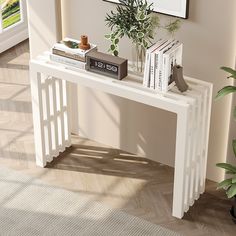 a white console table with books and plants