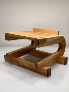 a wooden table that has been designed to look like a chair with one foot on it