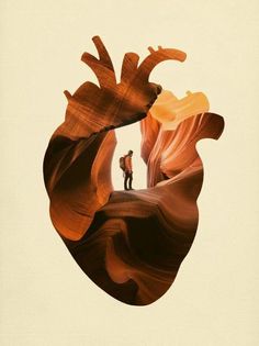 a man standing on top of a cliff next to a giant heart shaped piece of wood