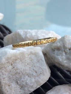 a gold ring sitting on top of some rocks