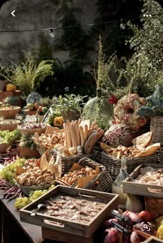 a table filled with lots of different types of foods and vegetables in baskets next to each other