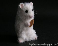 a white toy hamster sitting on top of a black table next to a brown tag