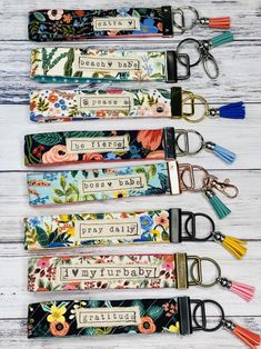 four key fobs with flowers and tassels on them