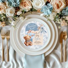 a white plate with a teddy bear on it next to gold forks and silverware