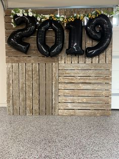 a wooden wall with balloons and flowers on it