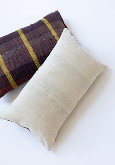 two pillows sitting next to each other on a white surface