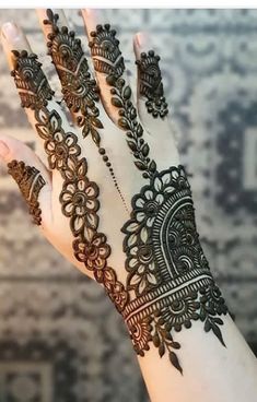 a woman's hand with henna tattoos on it