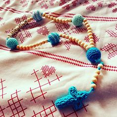 a beaded necklace is laying on a bed