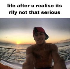 a man sitting on top of a boat next to the ocean with text that reads, life after u reallise its rly not that serious