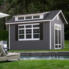 a backyard with a pool, chaise lounge and shed