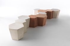 three wooden stools sitting next to each other on top of a white flooring