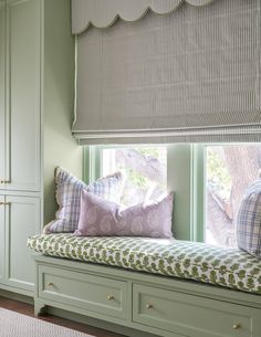 a window seat with pillows on it in front of some cupboards and windowsill