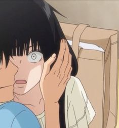 an anime character with black hair and blue eyes holding his hand up to his face