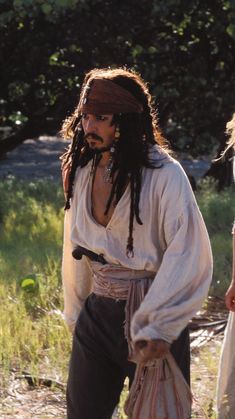 a man with dreadlocks is dressed in pirate garb and carrying a bag